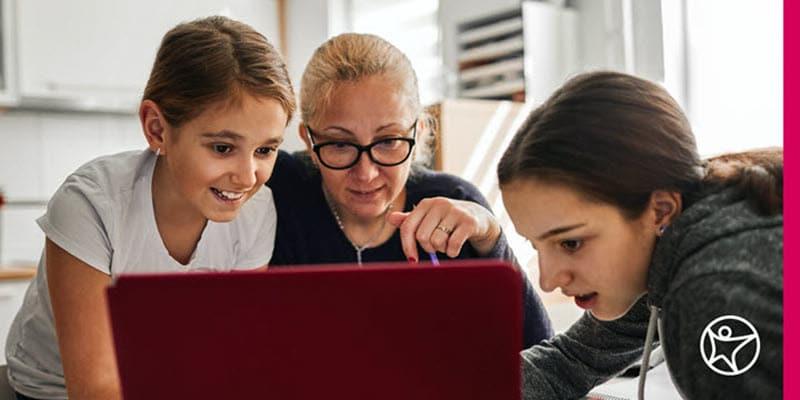 Mother and two daughters researching on laptop how much does online high school cost.